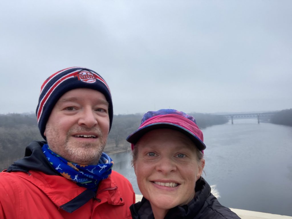 2 happy people with hats on the franklin bridge with the misty and foggy water of the mississippi river in the background