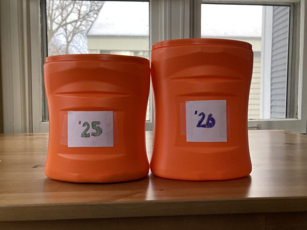 2 orange, cylindrical container. The one labeled '26 is larger than the other, labeled '25.