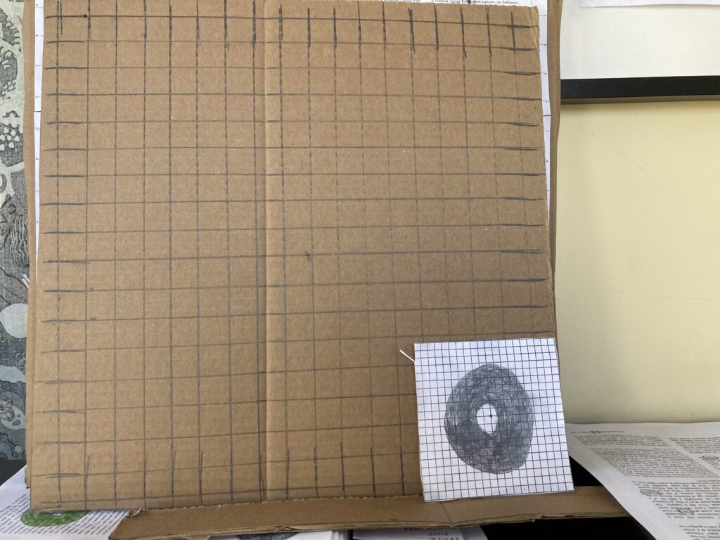 2 grids, a bigger one drawn with pencil on cardboard, a smaller one made from ink with by blind spot drawn on it