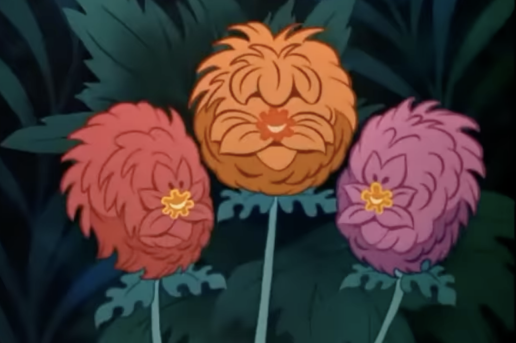 an orange ball of a flower flnaked by 2 pink flowers